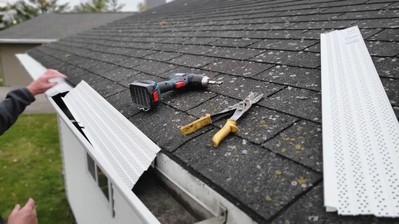 Roofer installing new vents and trim on a shingle roof