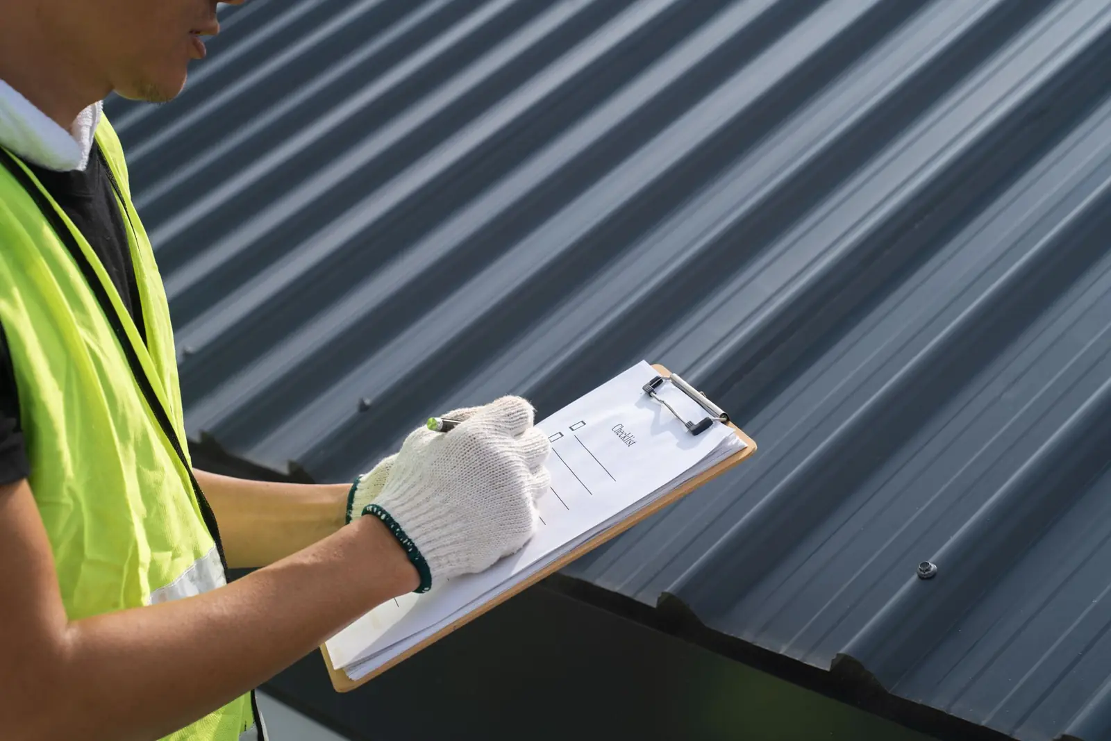 Inspector documenting roof damage on a clipboard