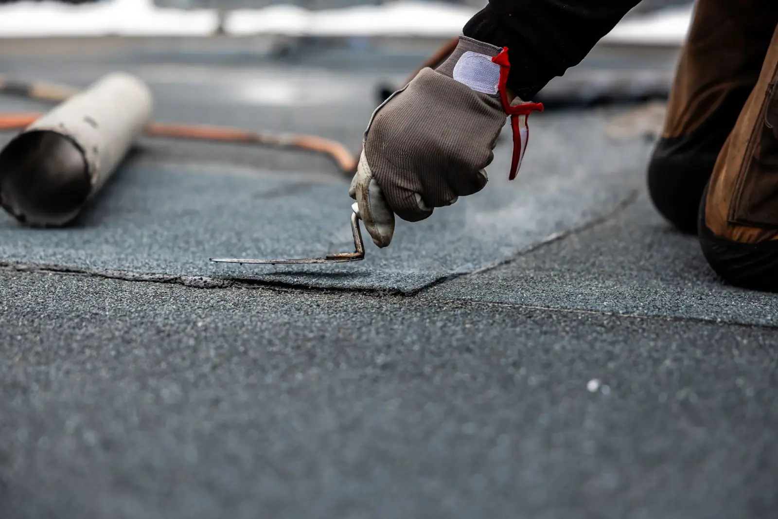 Roofer applying modified bitumen roofing