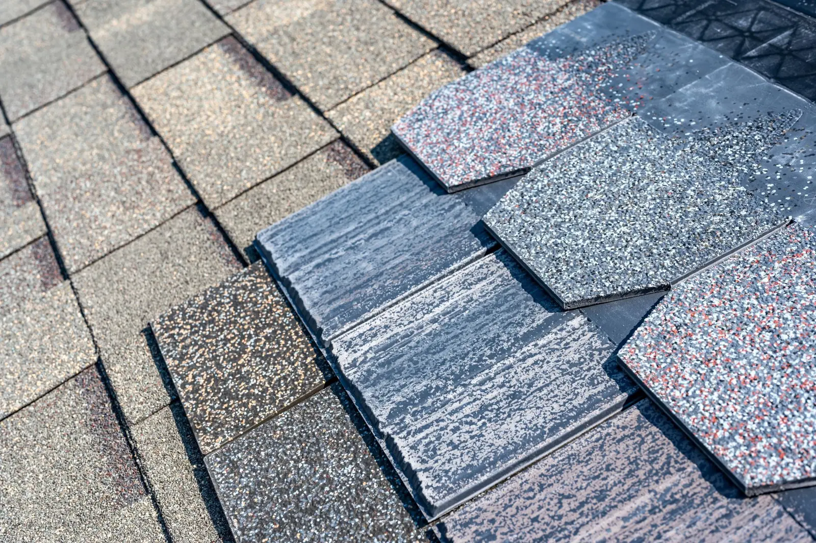 Close-up of a shingle roof with a section of new replacement shingles
