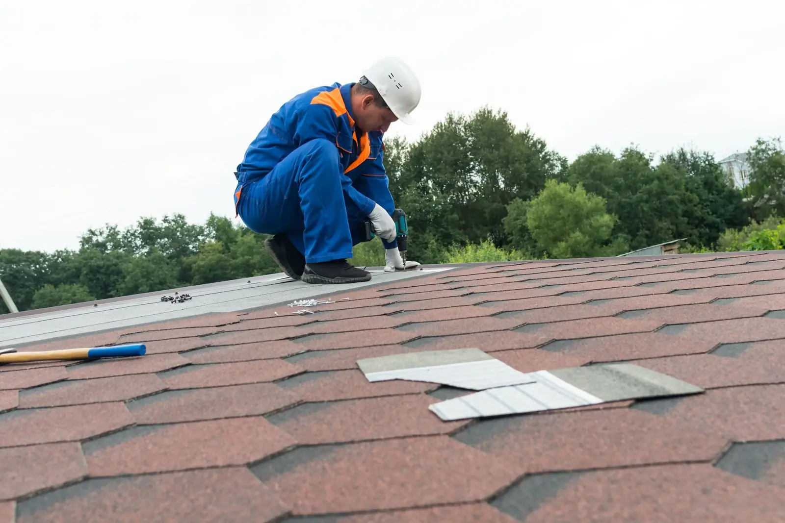 Roofer installing asphalt shingles